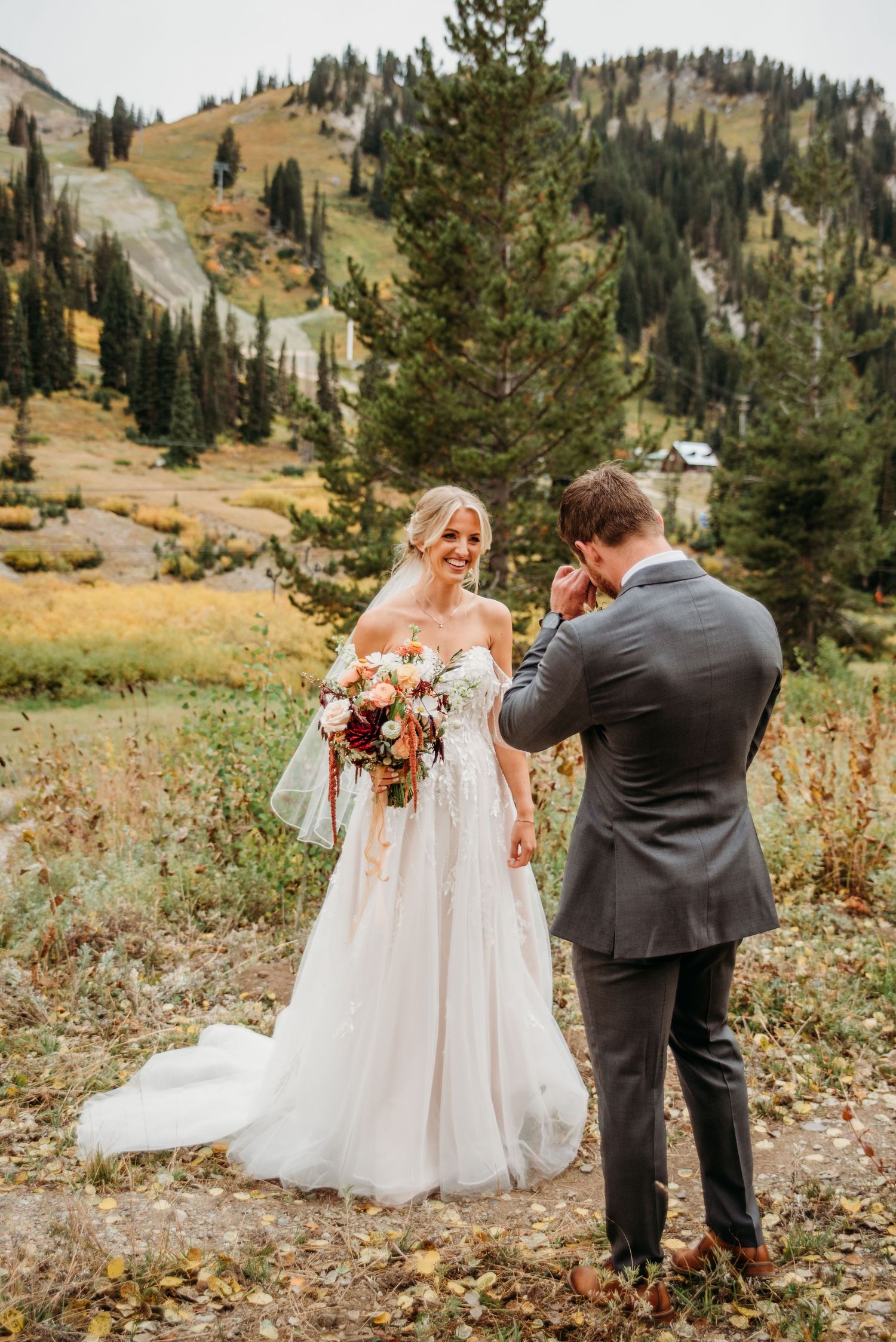 A couple shares a first look on their wedding day surrounded by mountain scenery and fall foliage.