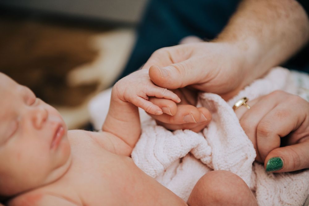 Close-up details of tender newborn care moments.