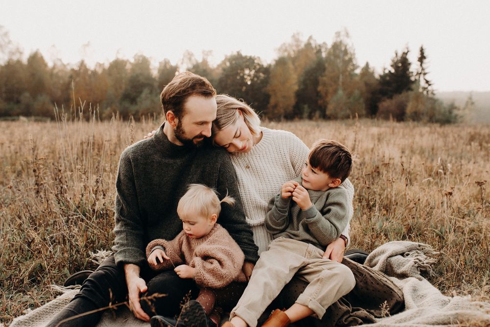 familj tillsammans fotograferade innan solen går ned på en filt