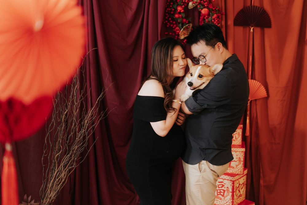 Couple sharing intimate moment with Chinese New Year decor in background.