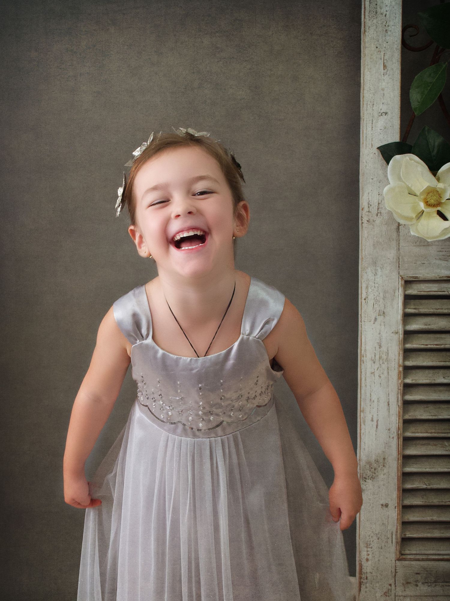 Young girl standing portrait,  smiling and wearing a grey dress