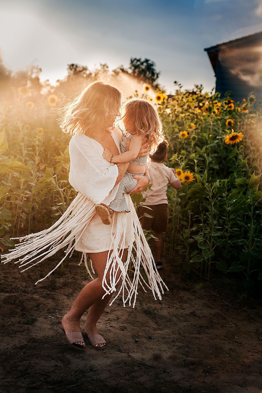 mom twirling with young dauhter in sunflowers