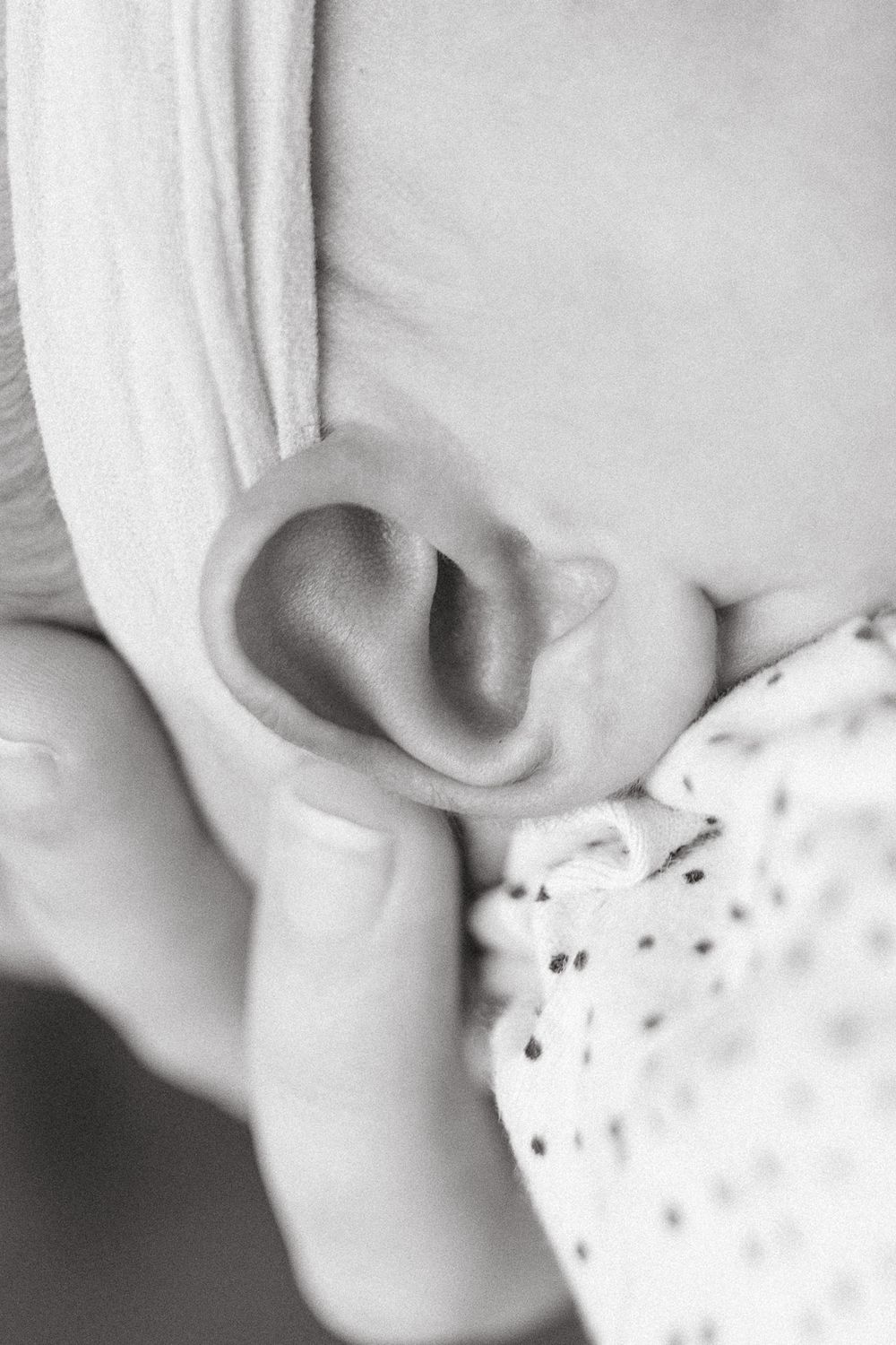 Black and white macro photograph of newborn baby's tiny ear.