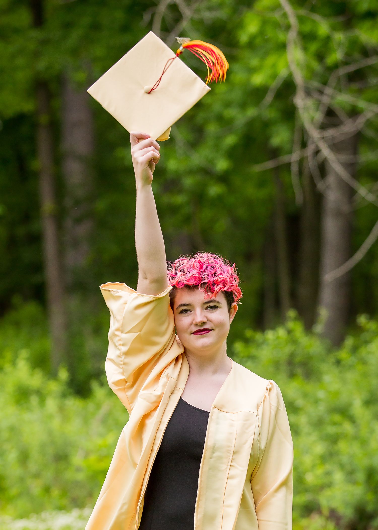 girl holding graduation cap in air cap and gown session beverly hills, mi