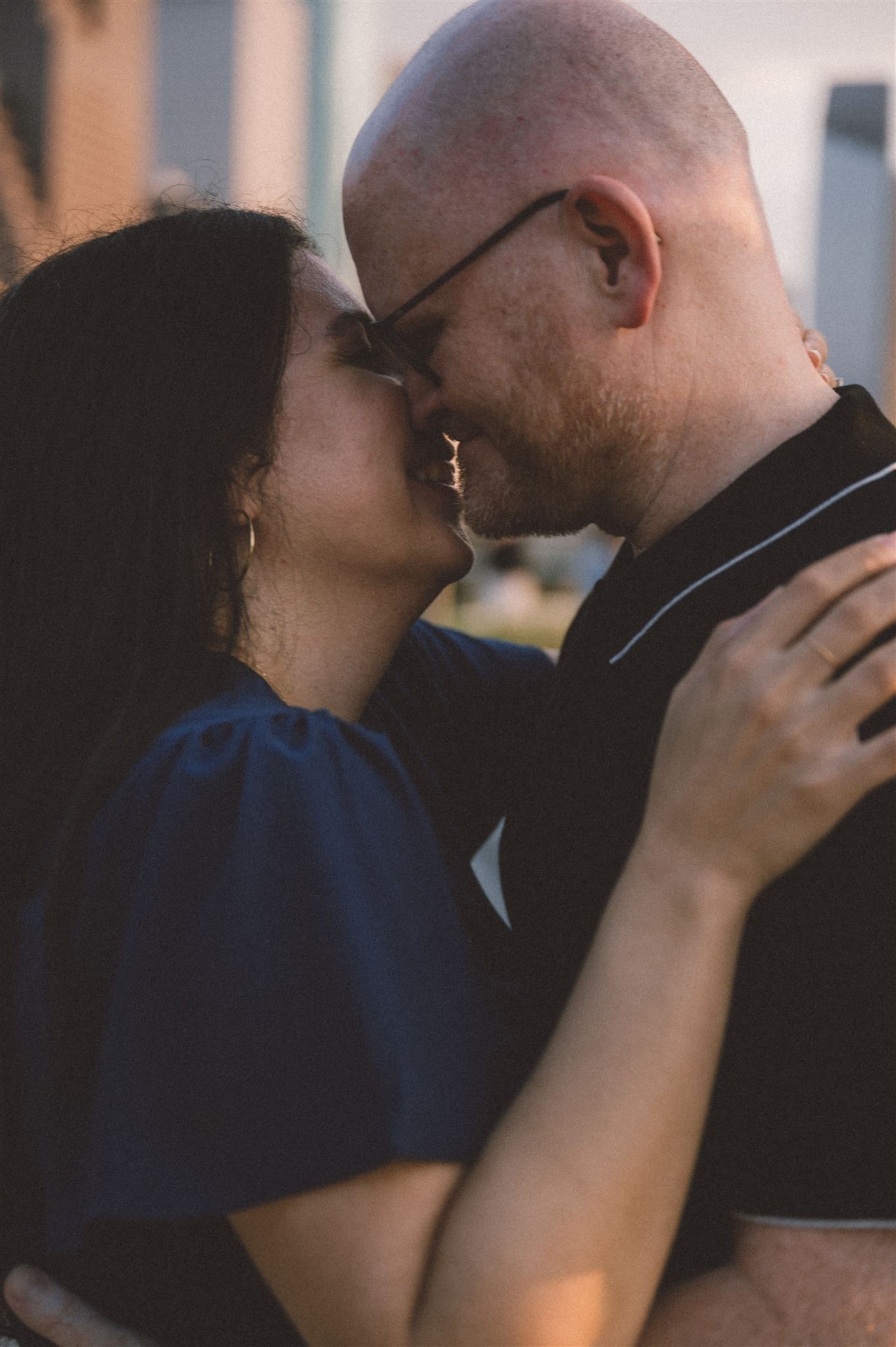 An intimate moment between a couple sharing a tender embrace in warm evening light.