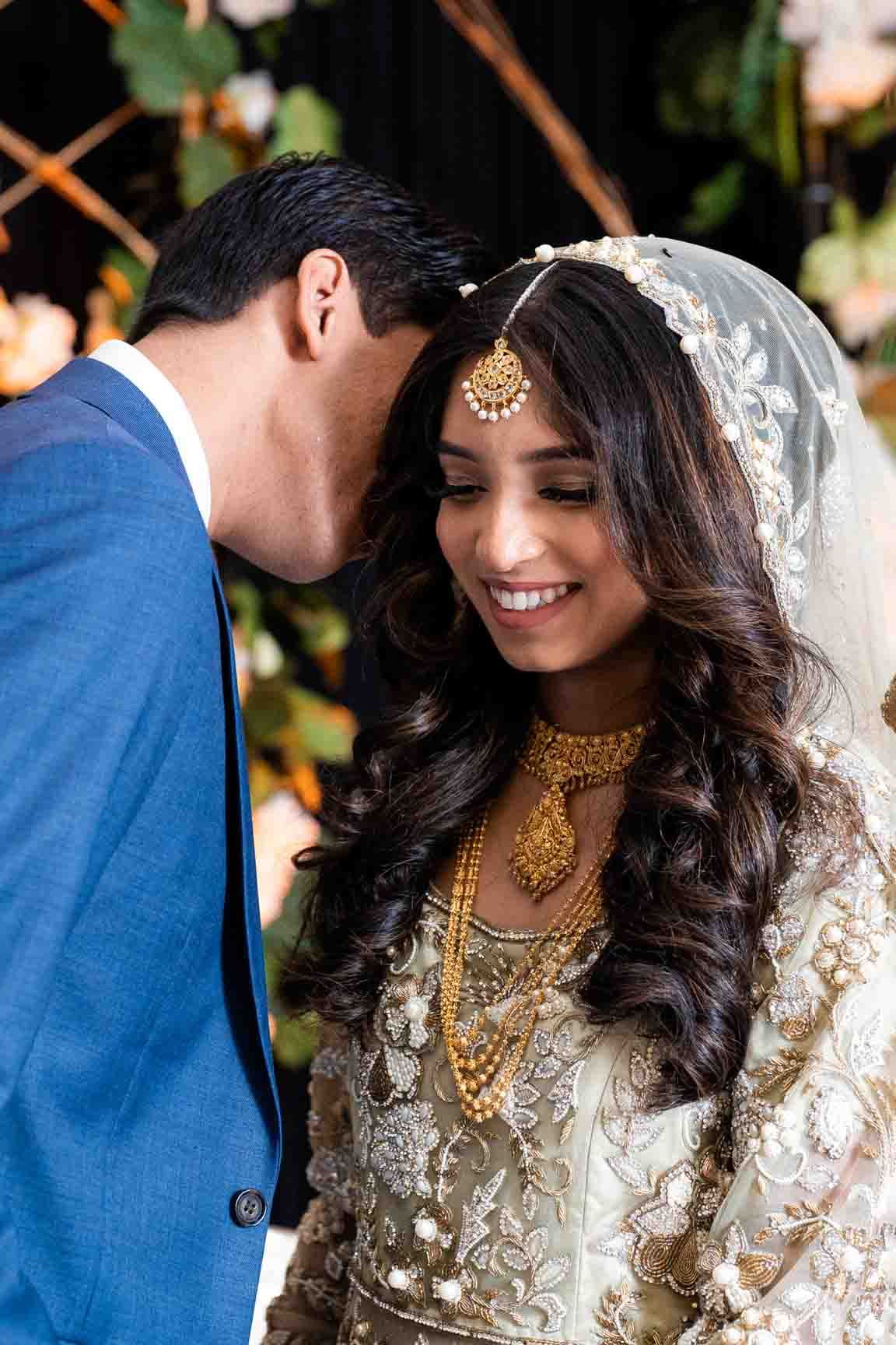 Groom's sweet words make Indian bride smile, a tender moment brimming with affection and shared happiness.