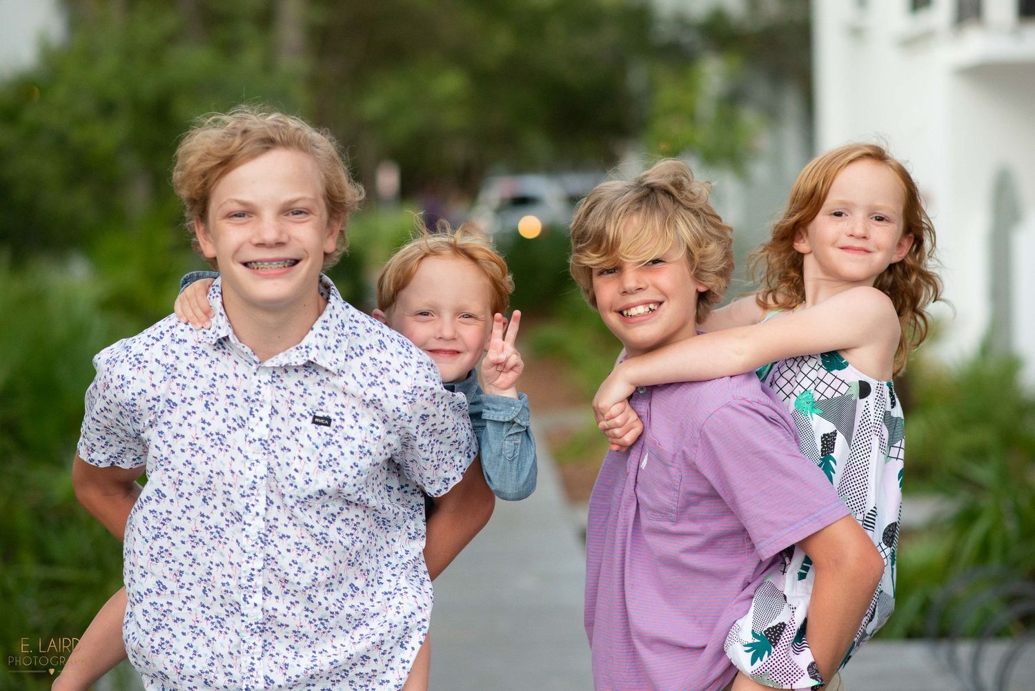 Children posing together outdoors on a summer day.