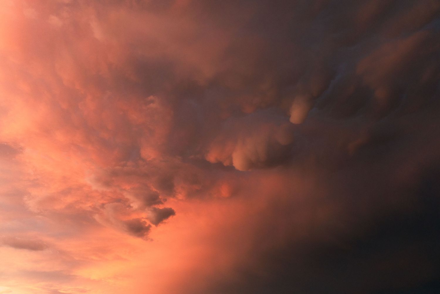Dramatic red and orange clouds fill the sky during a vibrant sunset.