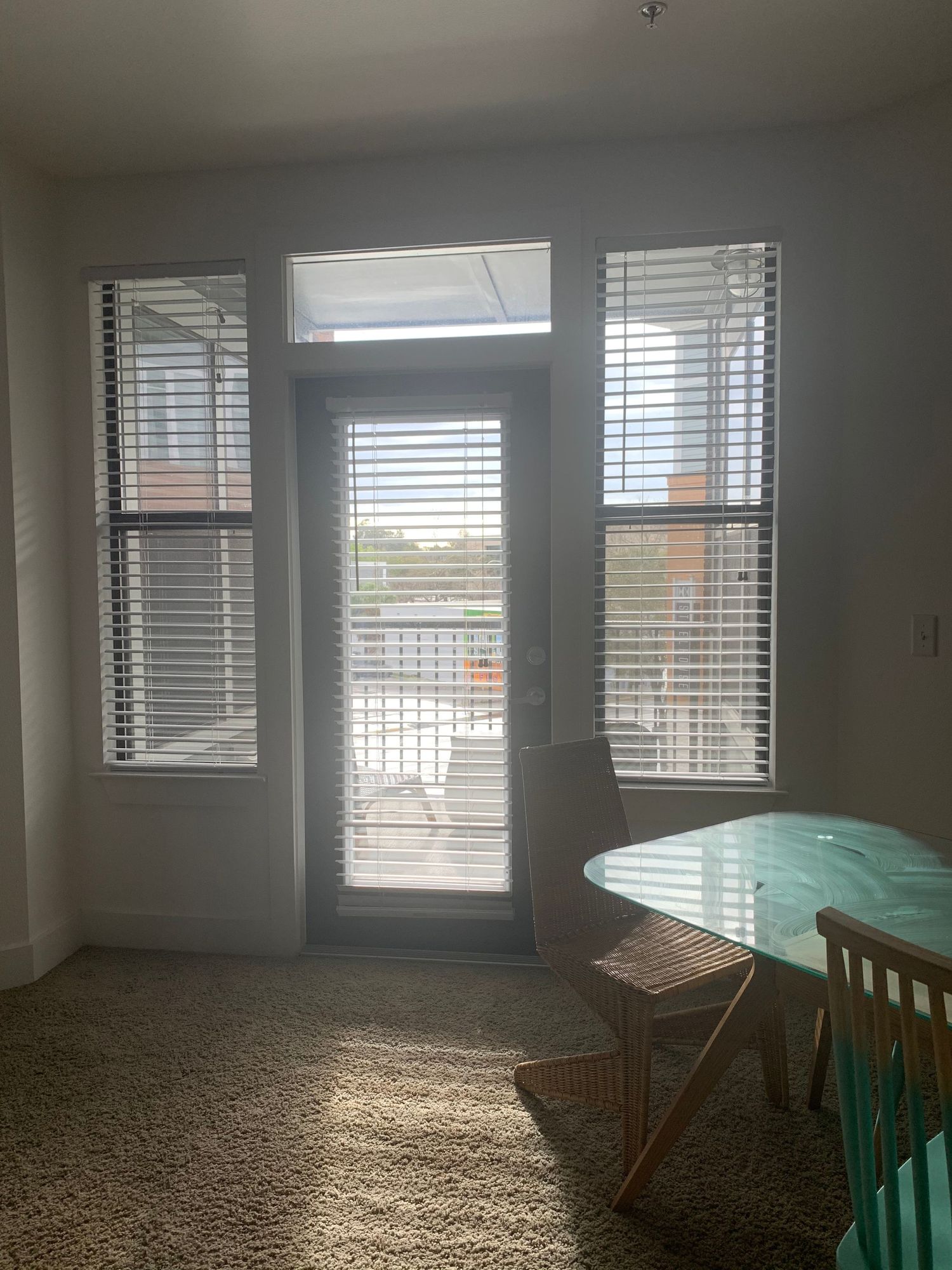 Bright room with multiple windows featuring horizontal blinds and natural light streaming in.