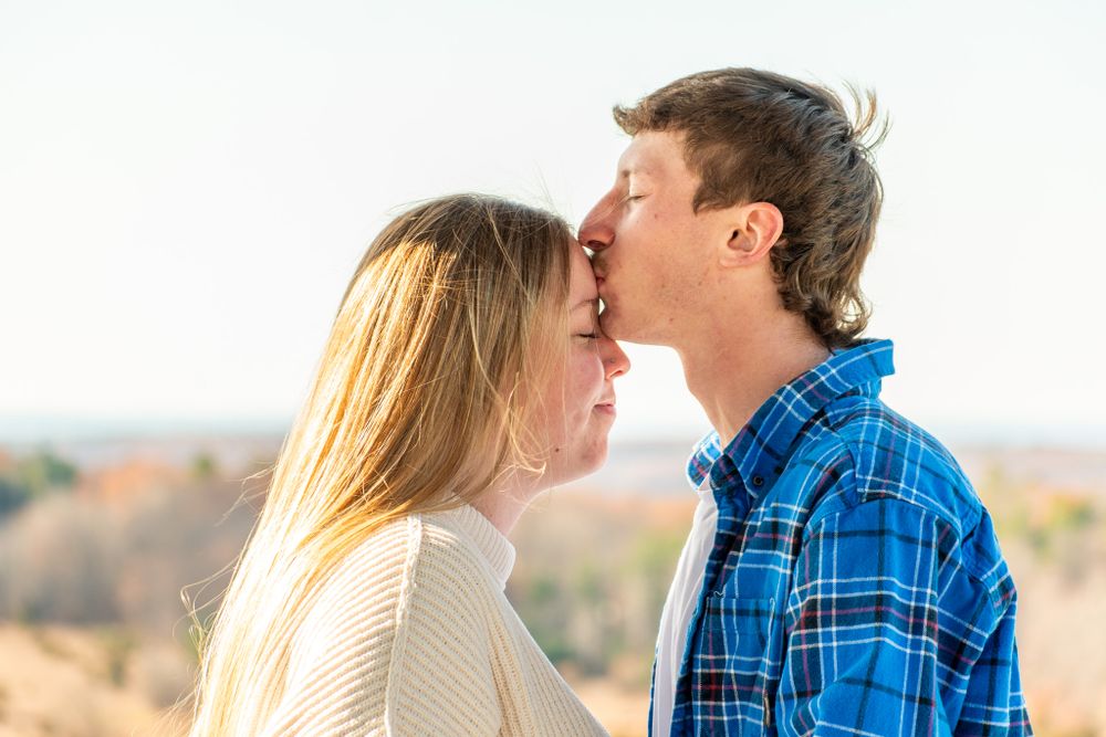A tender romantic moment captured between two people during golden hour.