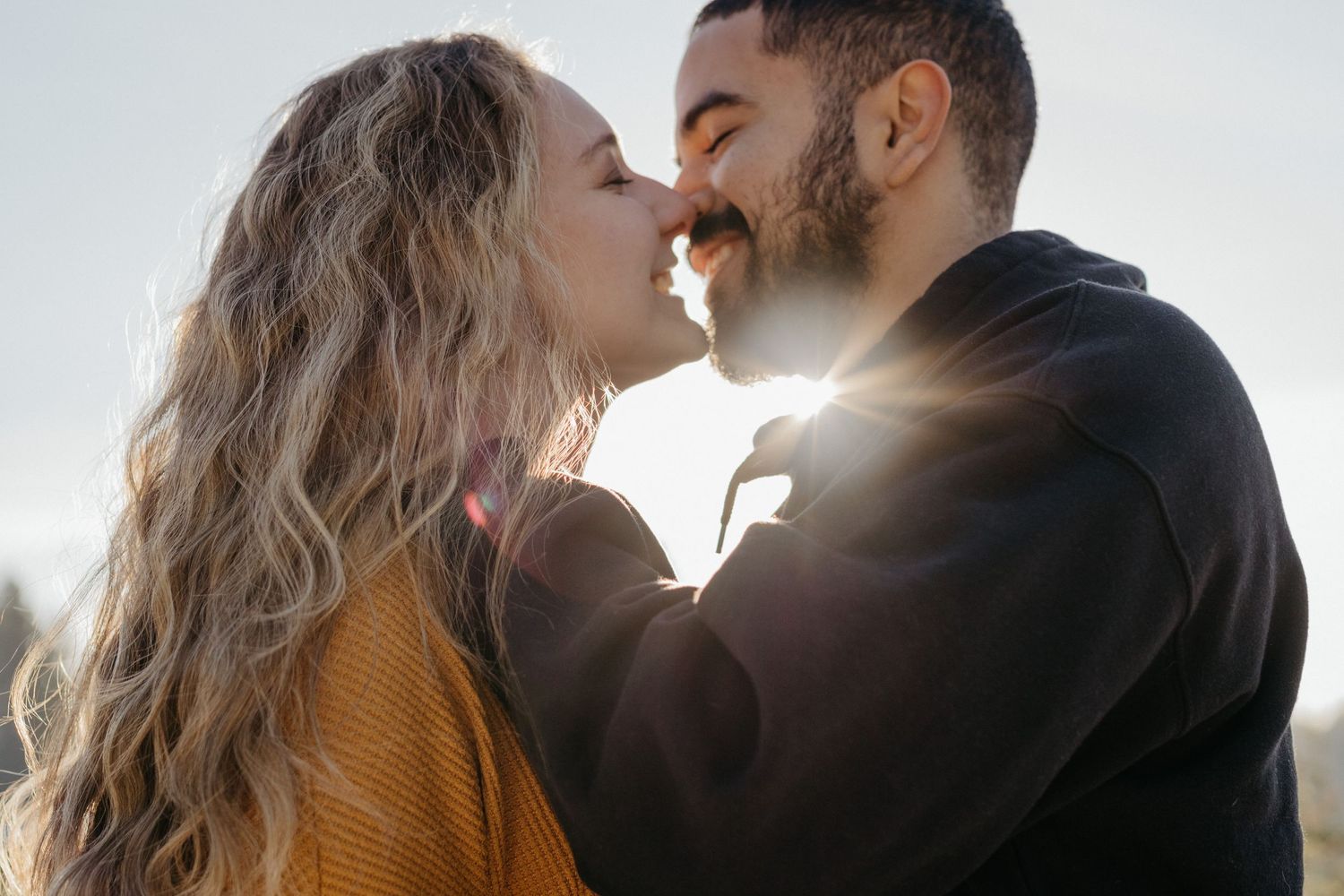 Romantic couple sharing an intimate moment in warm sunlight.