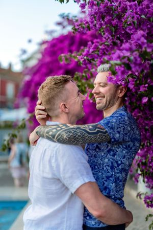 Gay couple photo session in a Lisbon garden with flowers in the background, in Alfama.