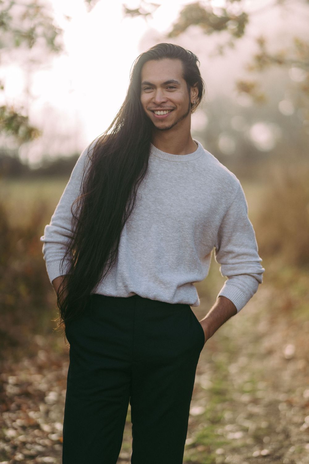 Natural lifestyle portrait showing casual gray sweater and long hair outdoors.