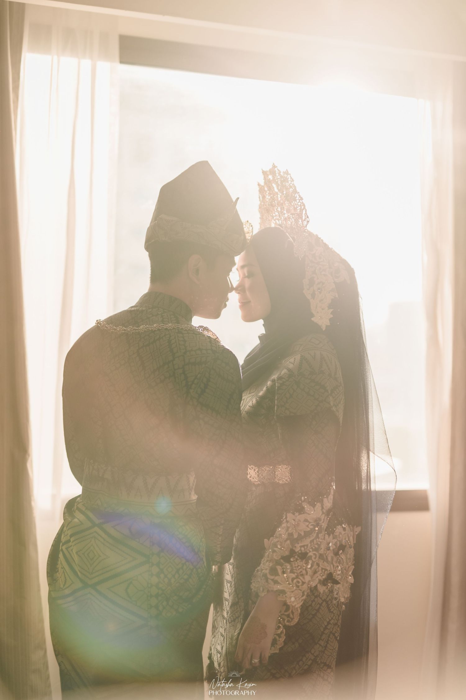 Silhouettes of people in formal attire against bright window backlighting.