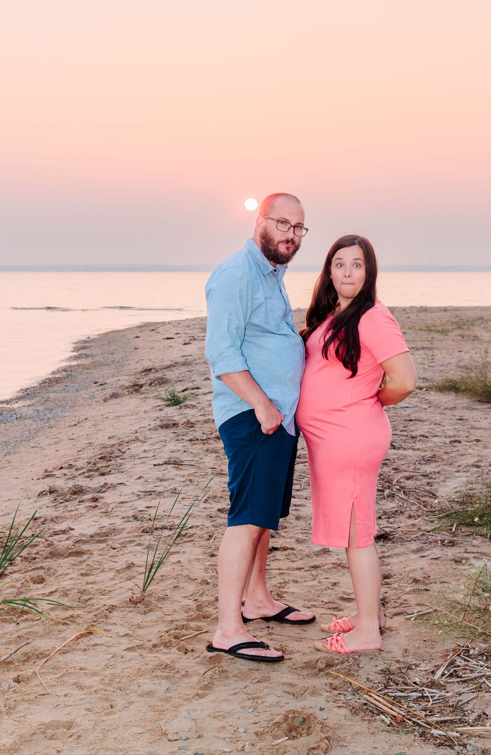 Playful maternity portraits on the beach at sunset