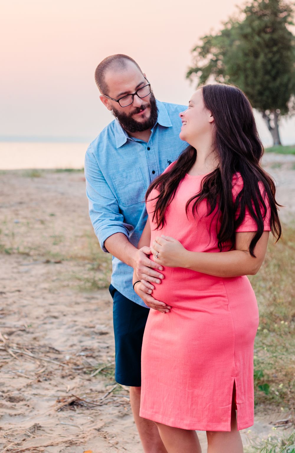 Playful maternity portraits on the beach at sunset