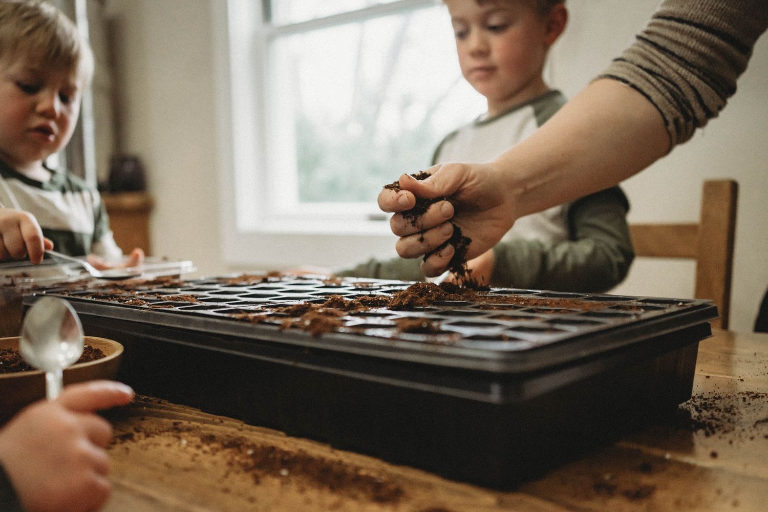 Close-up of hands working with baking equipment on a wooden table.