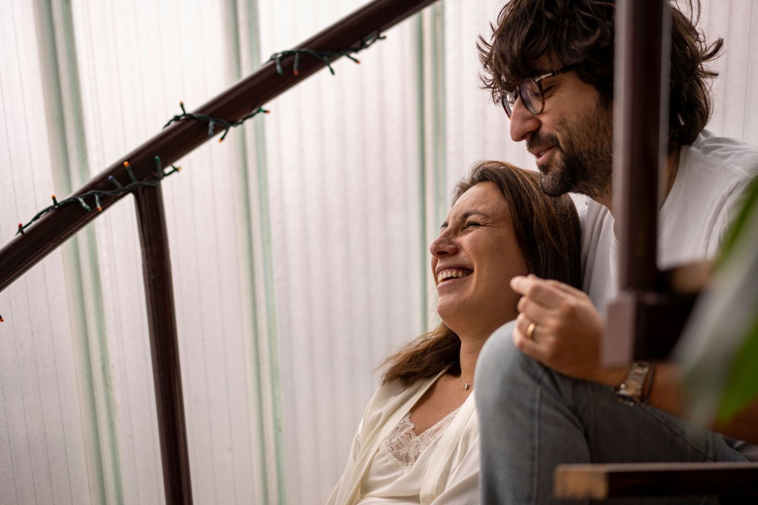 A couple sharing laughter during an intimate maternity photo session.