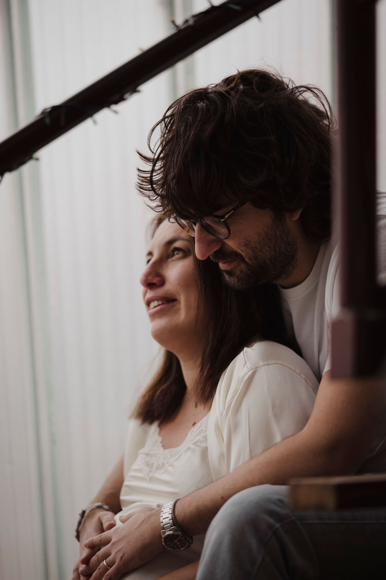 Intimate close-up of a couple sharing a tender moment by window light.