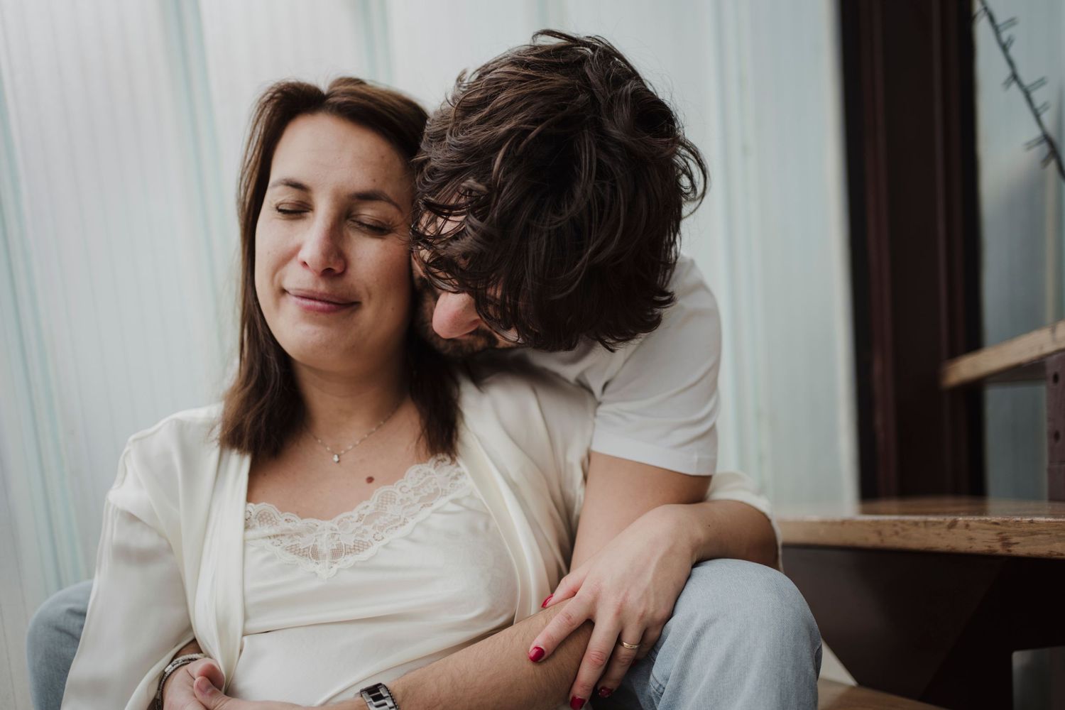 Tender embrace captured during indoor maternity photography session.
