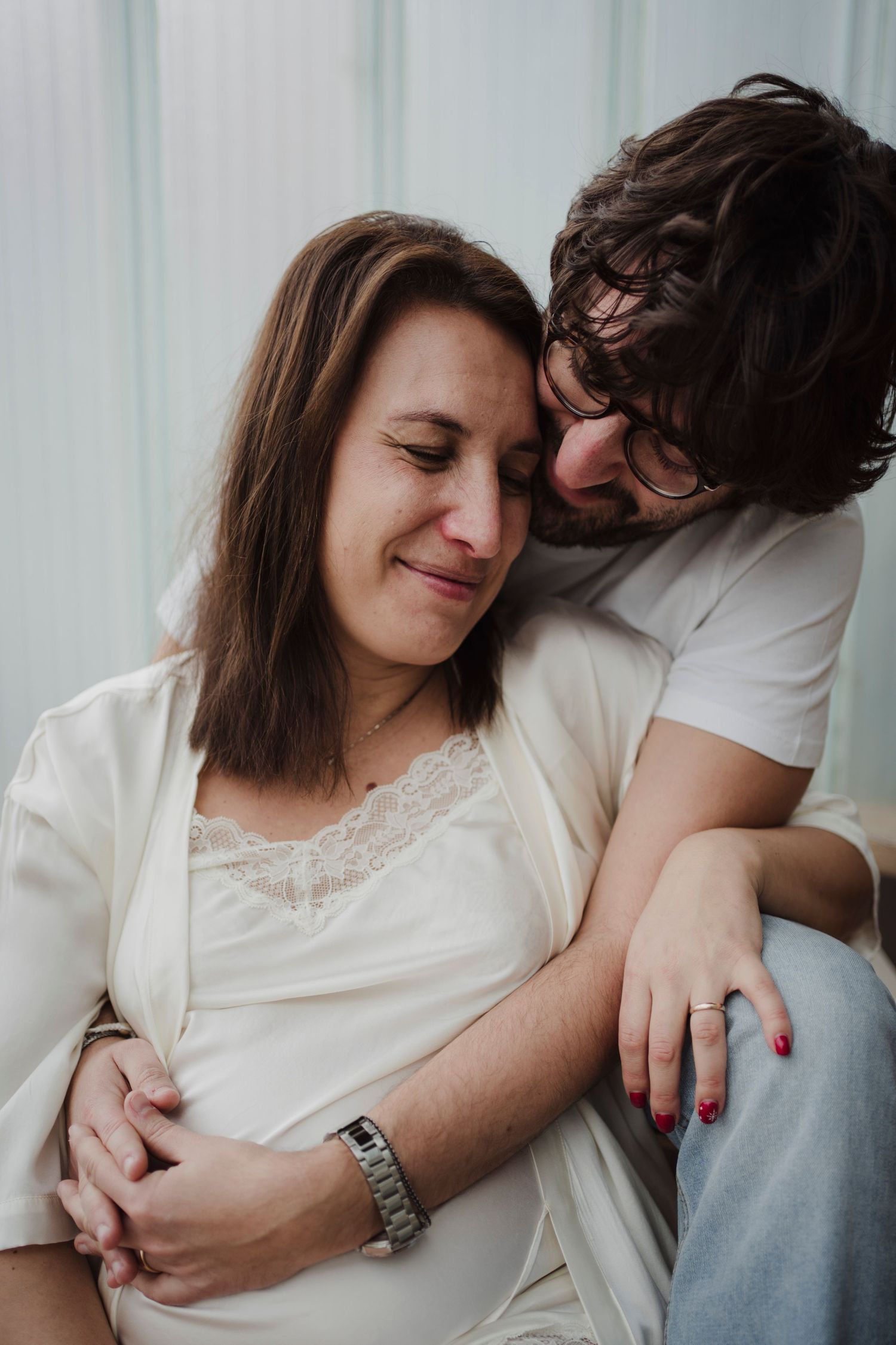 Intimate close-up of couple sharing gentle moment during pregnancy photoshoot.