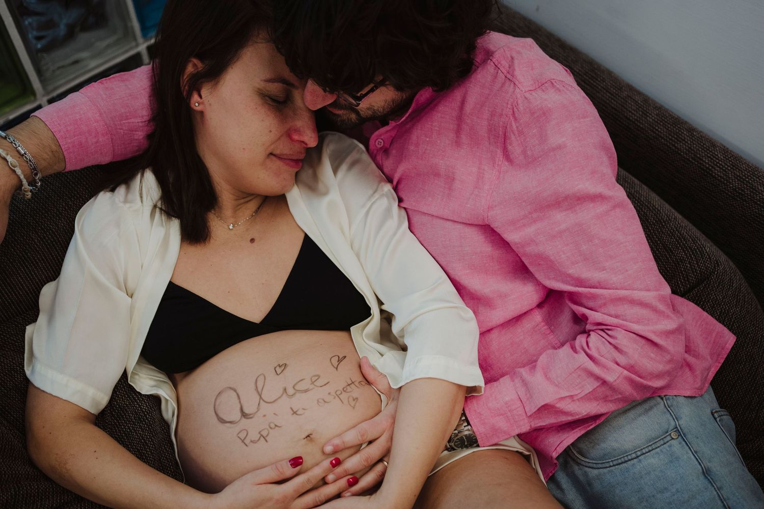 Emotional maternity moment showing handwritten belly art.