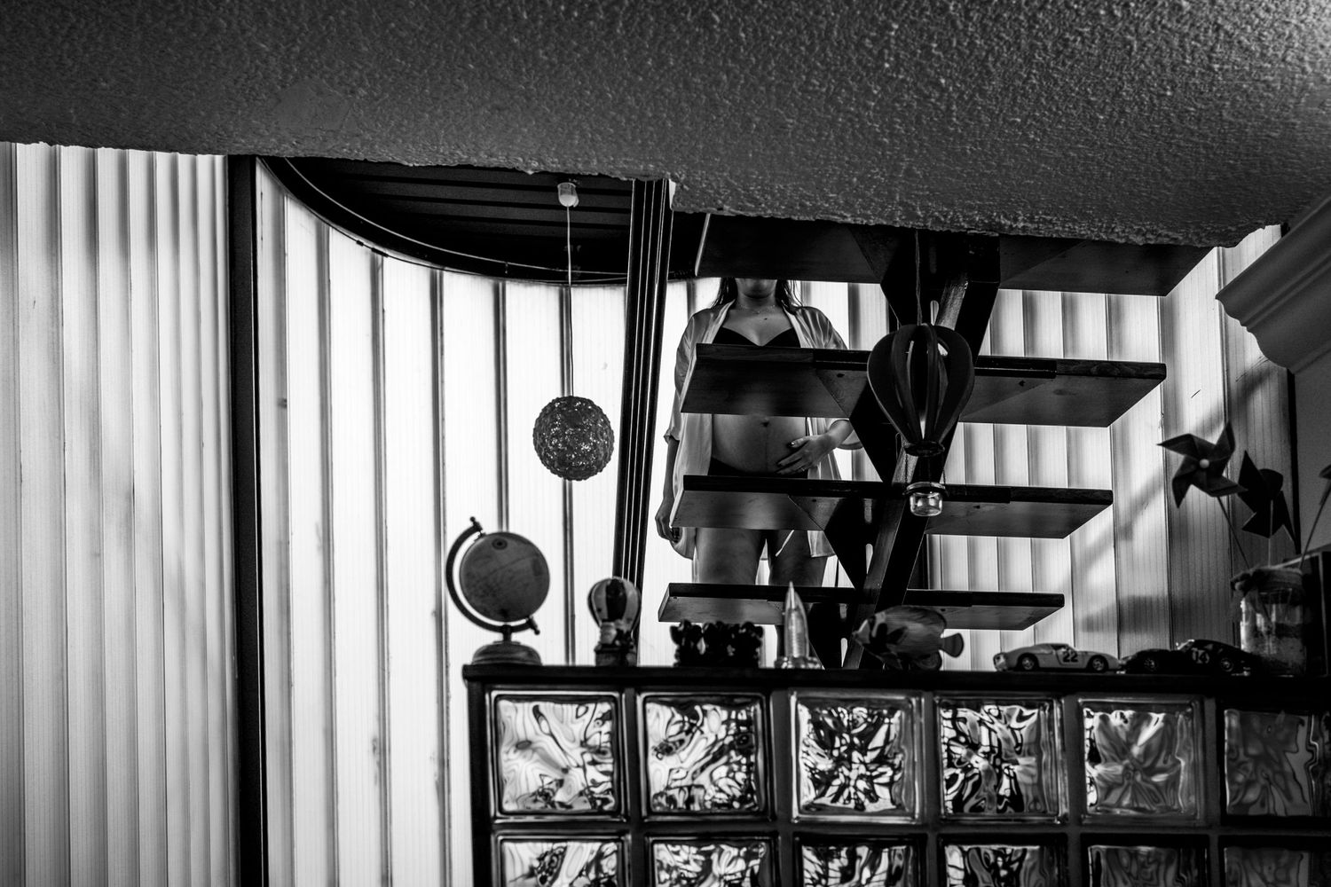 Abstract black and white interior shot with vertical blinds casting shadows.
