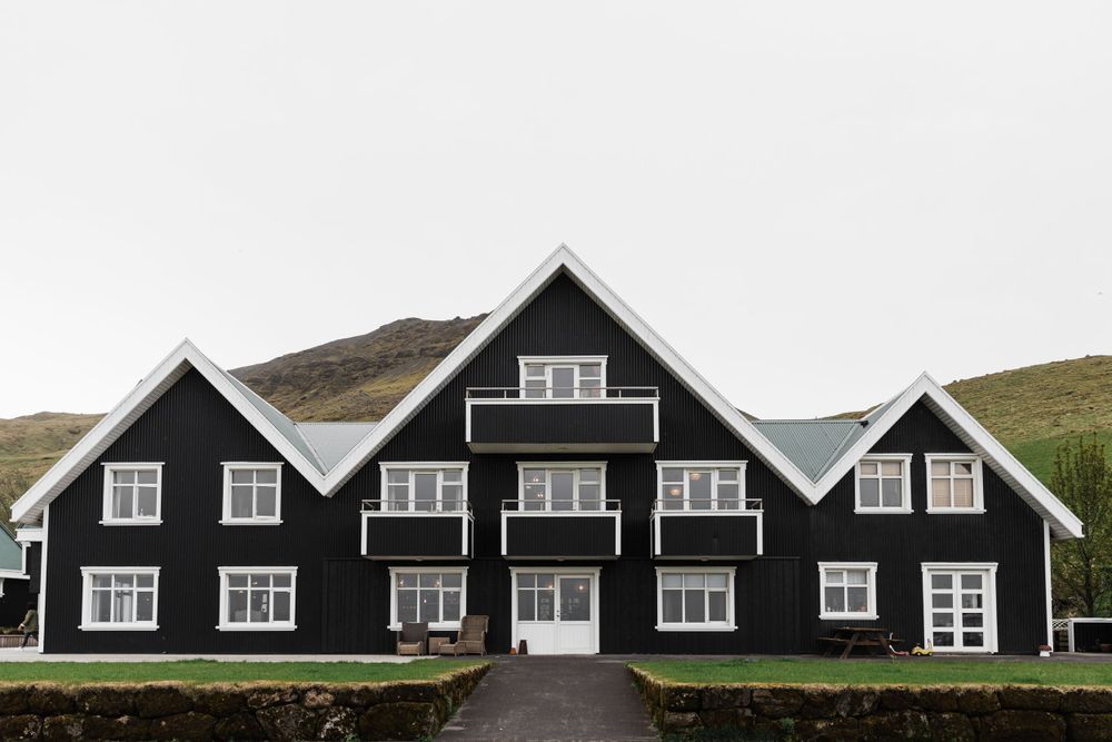 Modern black apartment building with white trim and multiple balconies in Scandinavian style.