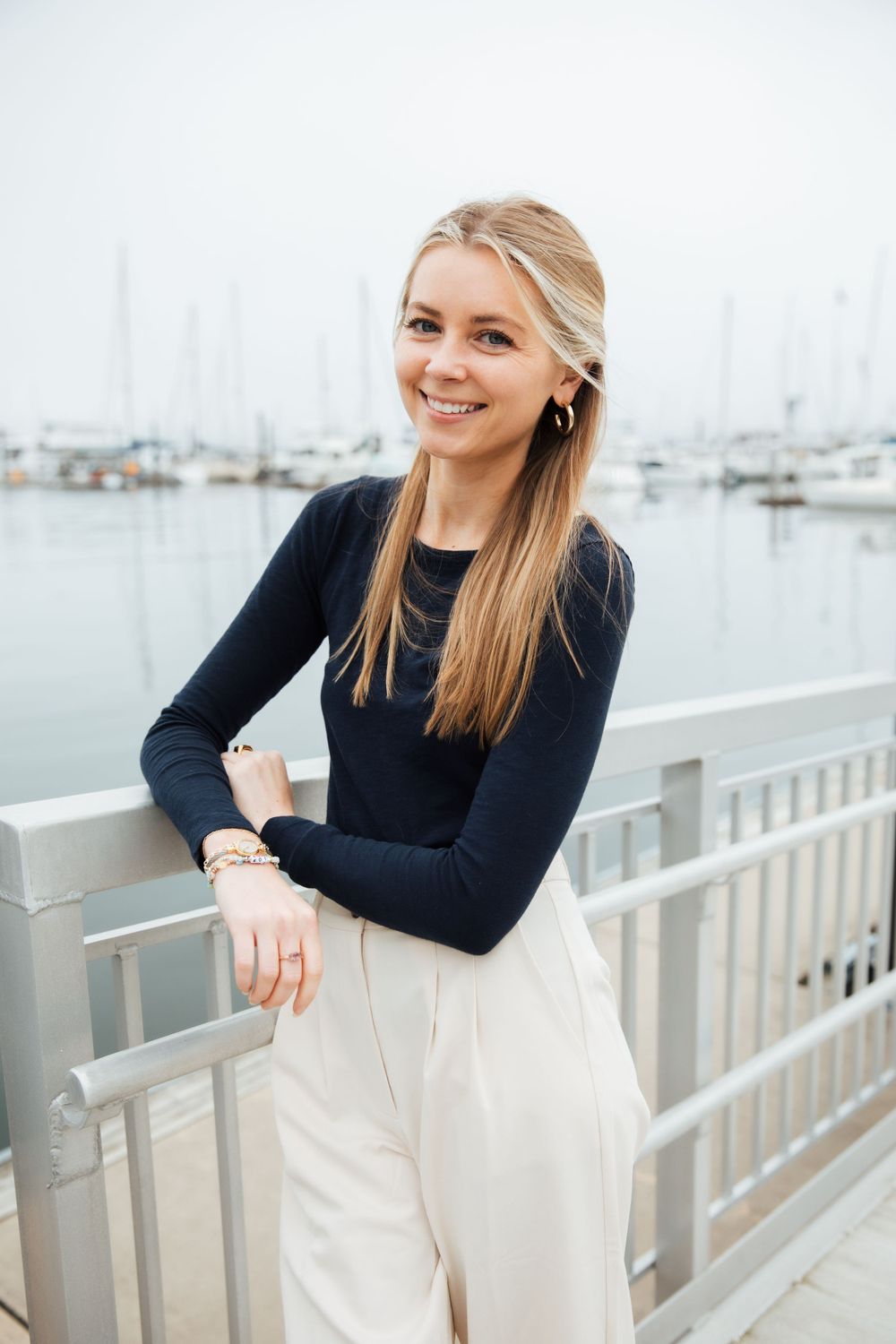 Modern nautical style outfit with navy top and cream pants at marina dock.  Branding photography. headshot. Newport Rhode island