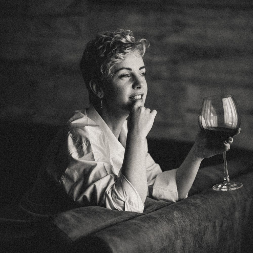 Vintage style black and white photo of someone relaxing with wine glass.