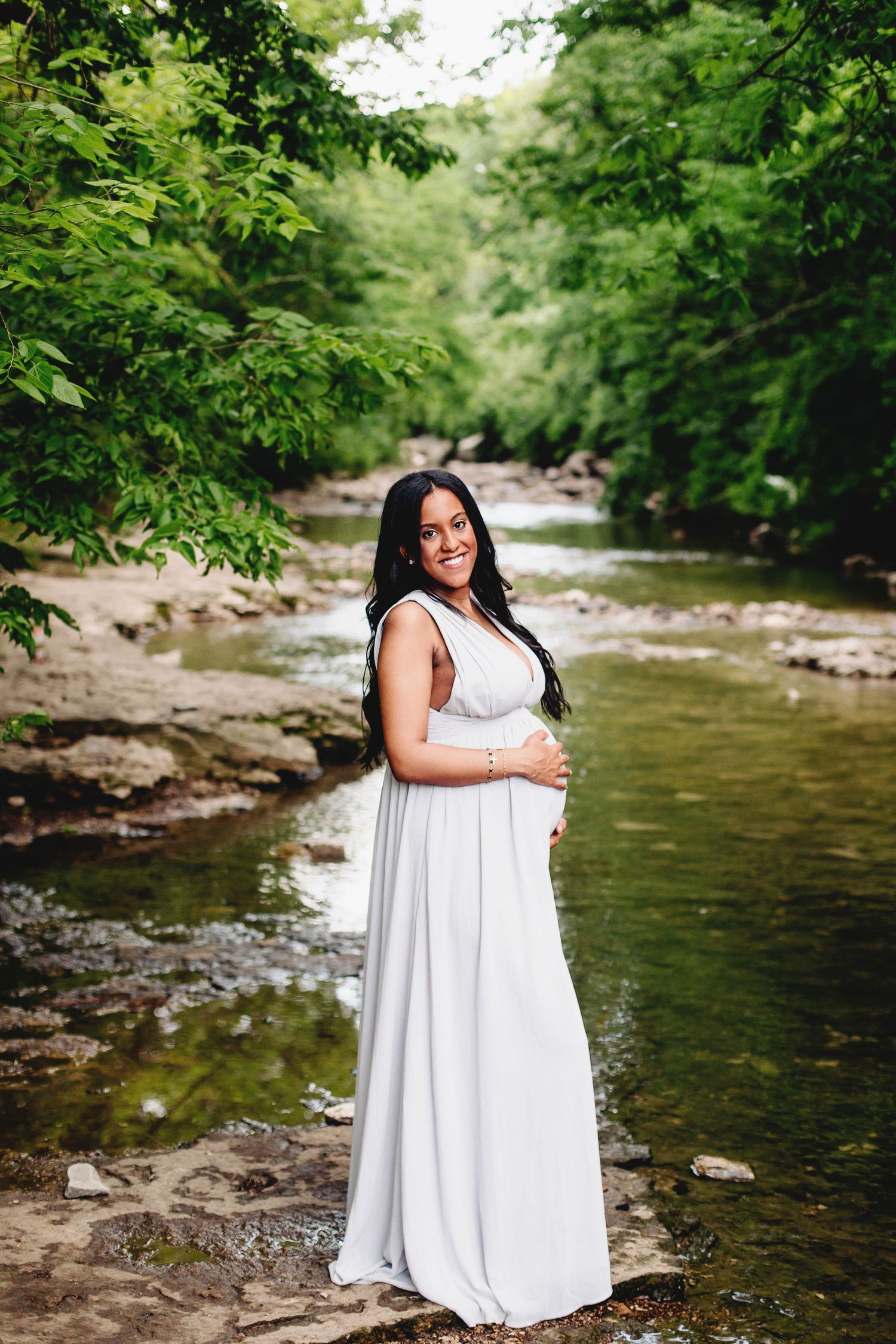 woman smiling and holding pregnant belly