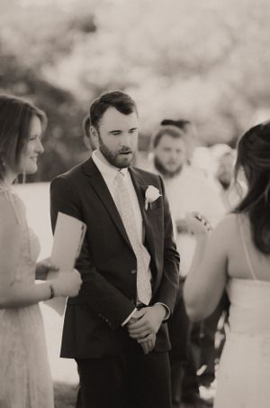 Black and white photo of wedding guests mingling at outdoor reception.