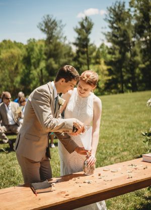 Newlyweds enjoying a rustic lawn game together at their outdoor celebration.