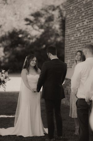 Vintage-style black and white photo of wedding guests at outdoor gathering.
