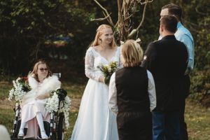 Wedding guests and children gathered outdoors in formal attire.