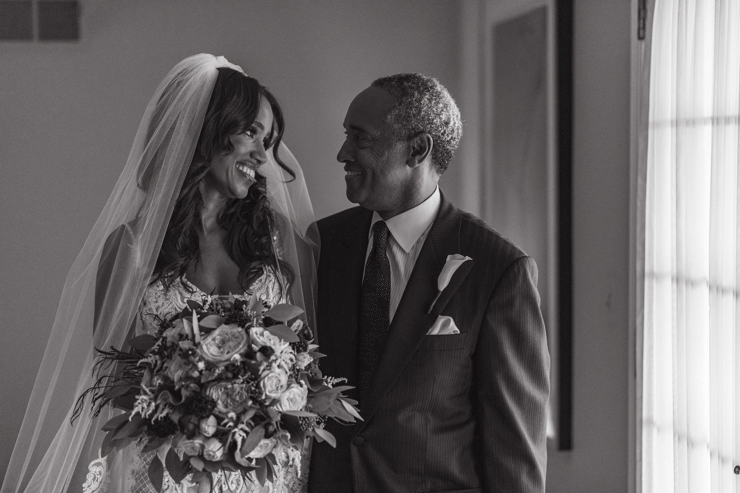 An intimate black and white moment between newlyweds with a floral bouquet.