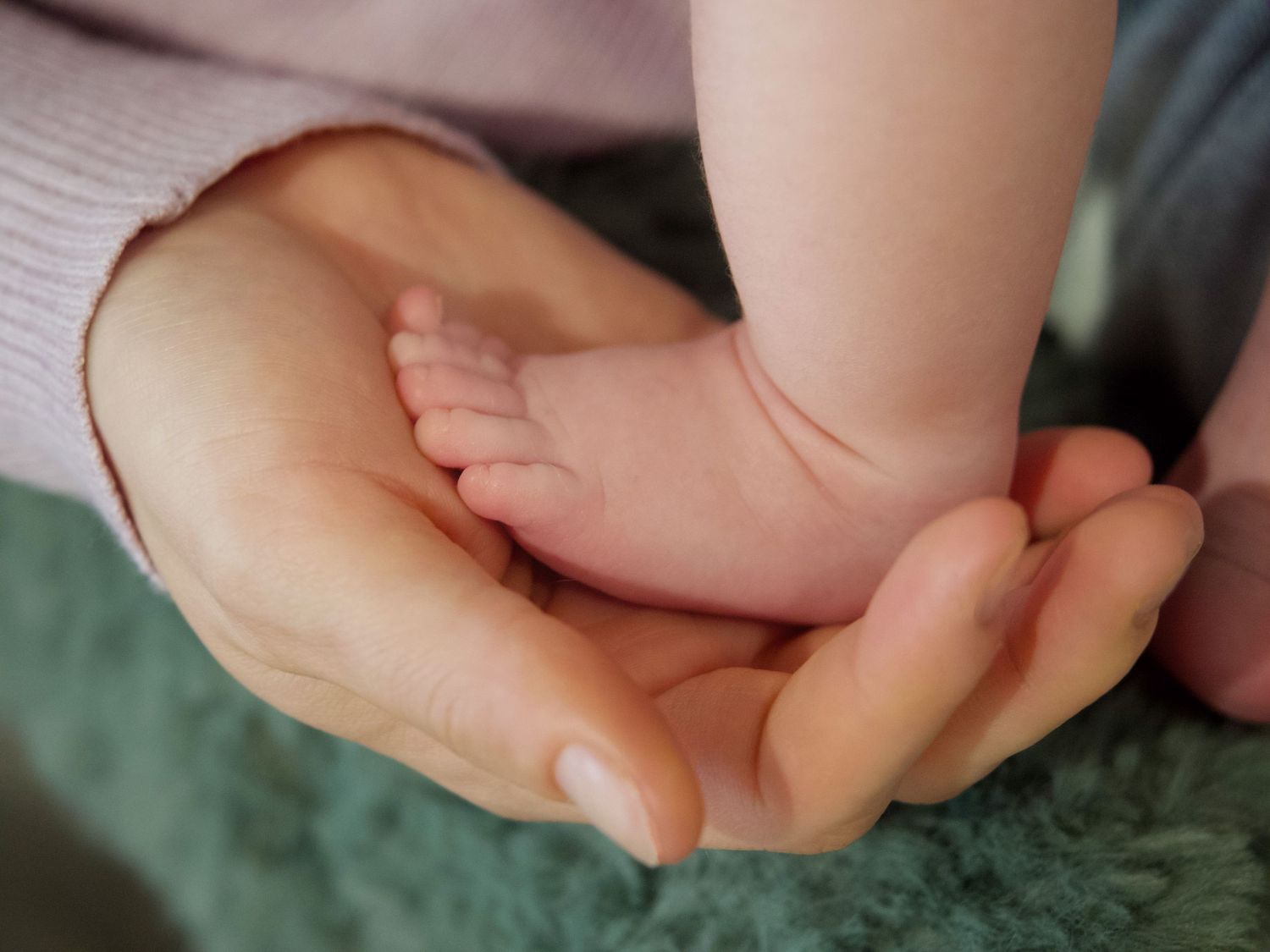 Lifestyle newborn photo session of a mothers hand holding a baby's foot