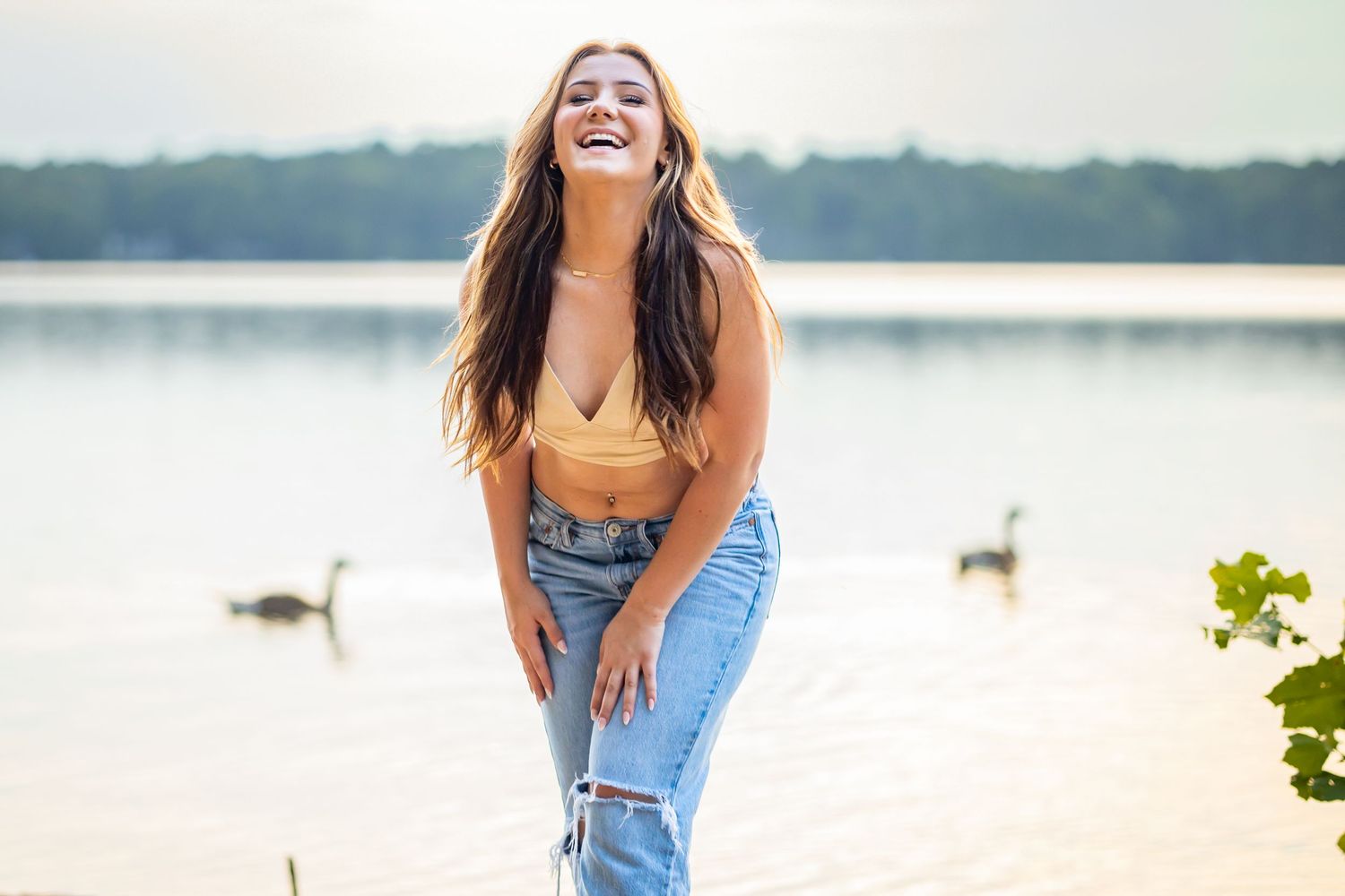 Summer portrait of casual style at lakeside with candid laughter and natural lighting.