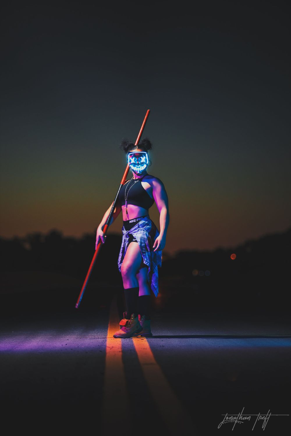 Sara in light mask holding bo staff