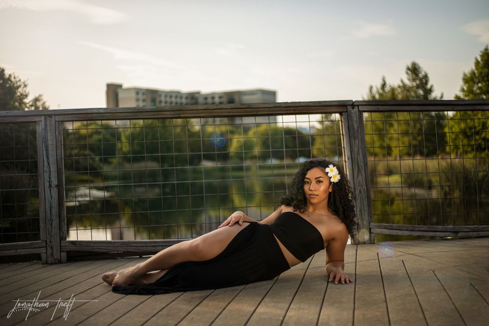Sara laying on the pier in a black dress
