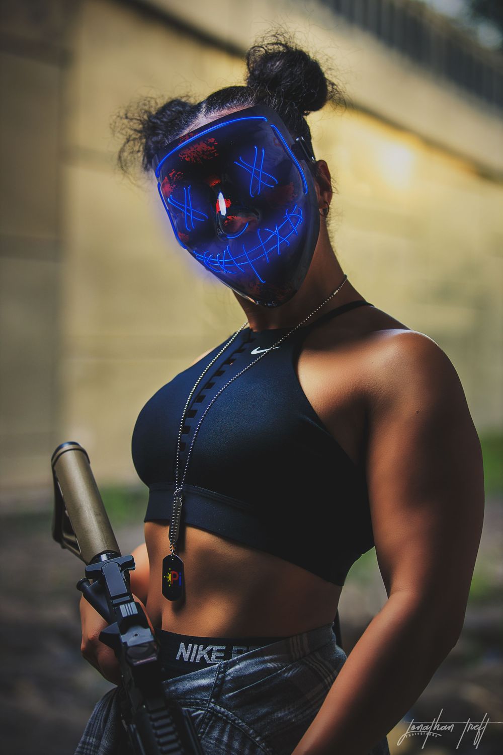 Close up of Sara in light mask looking at camera while holding M4