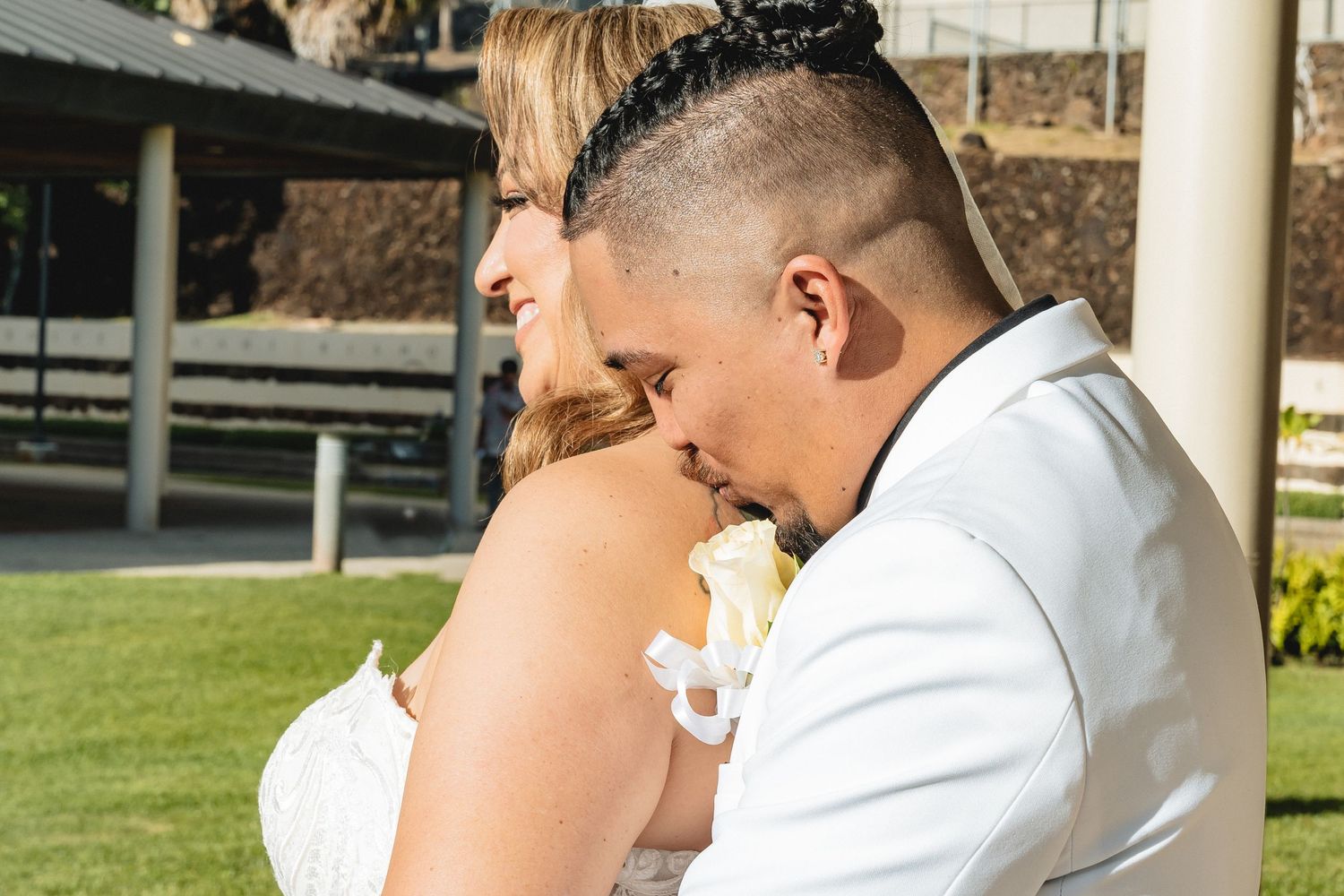 An intimate wedding moment captured outdoors with a white floral bouquet.