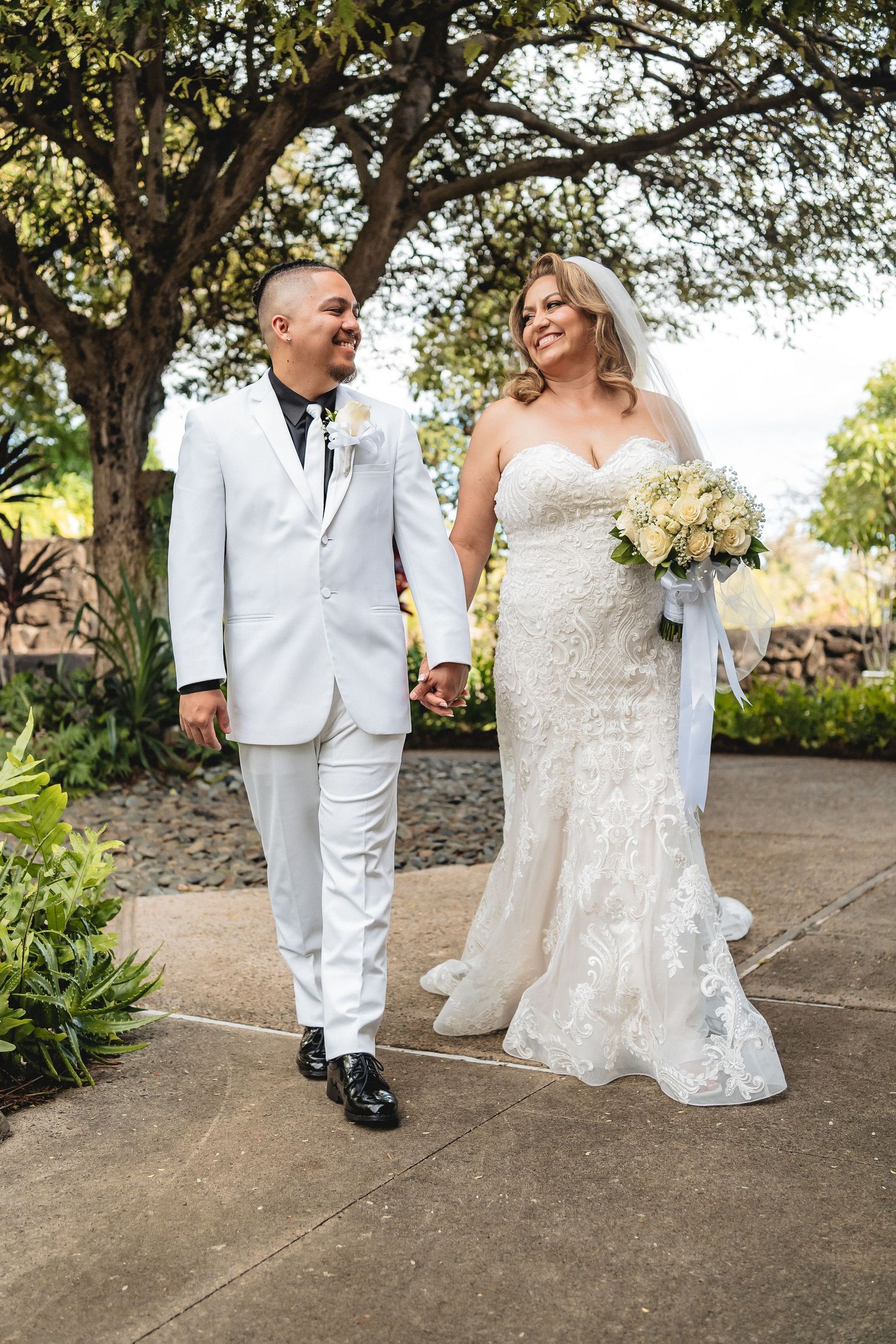 Newlyweds share a laugh while walking together on their wedding day.