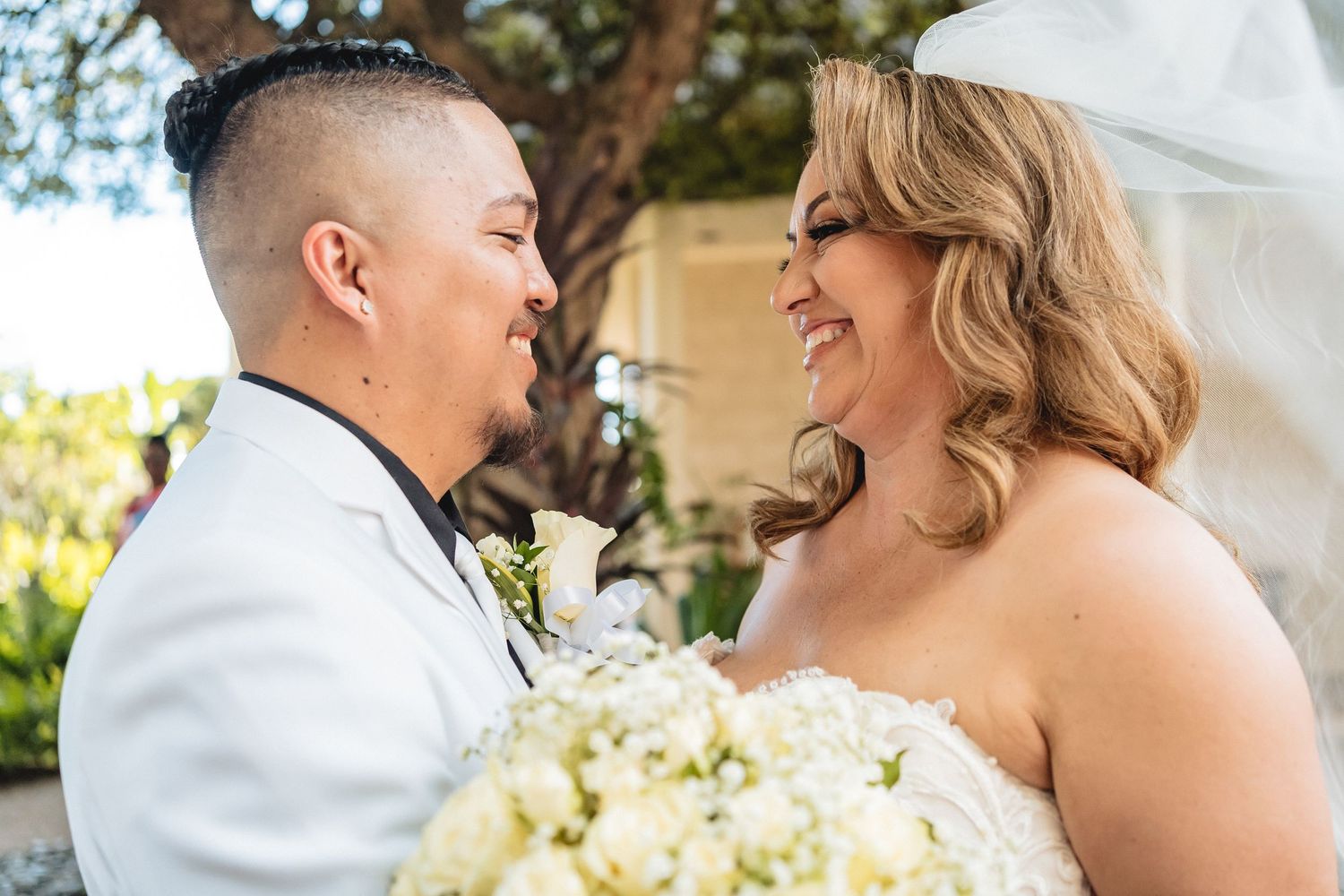 Happy couple shares laughter during their outdoor wedding photoshoot.