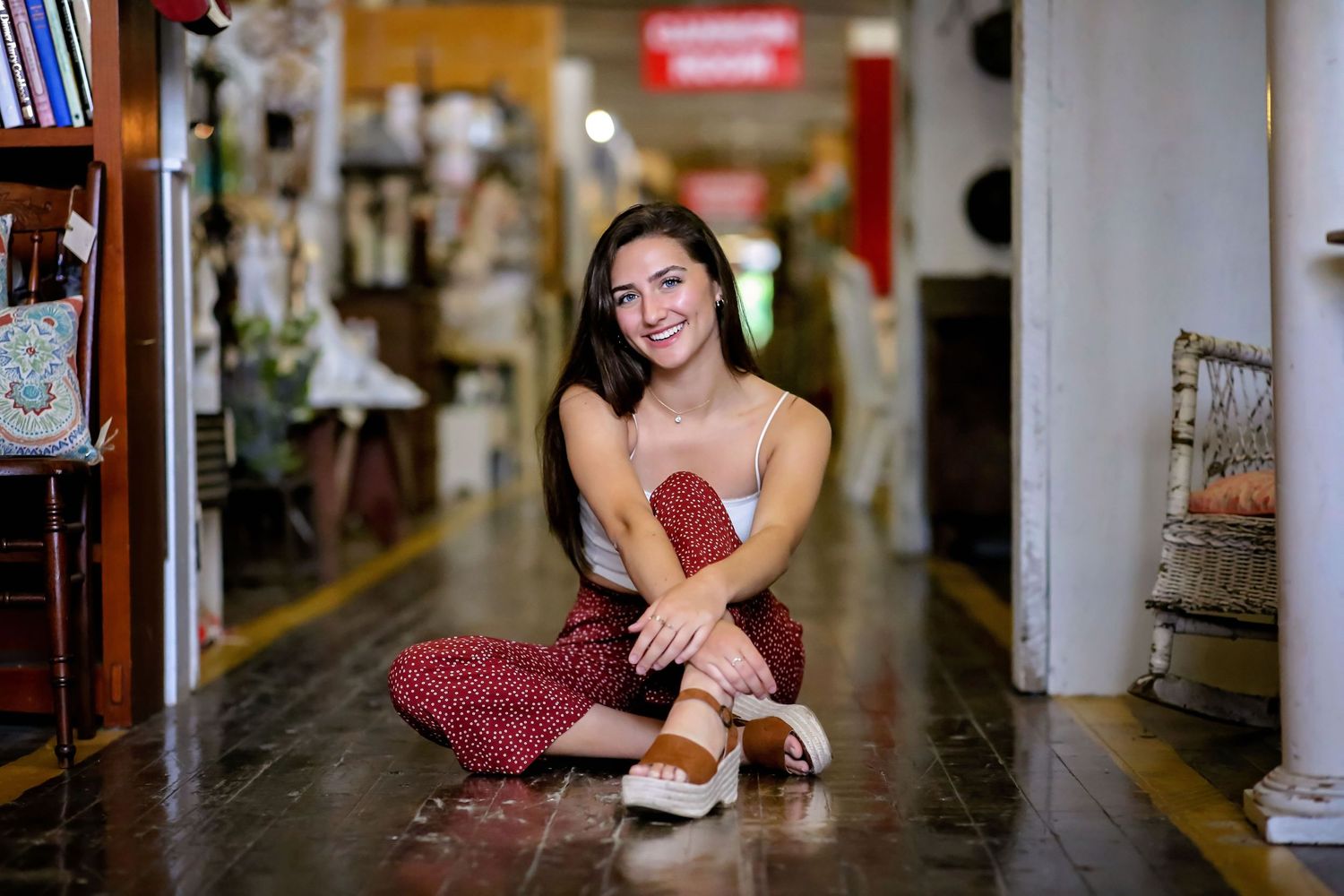 Casual indoor portrait sitting on floor of trendy bookstore.