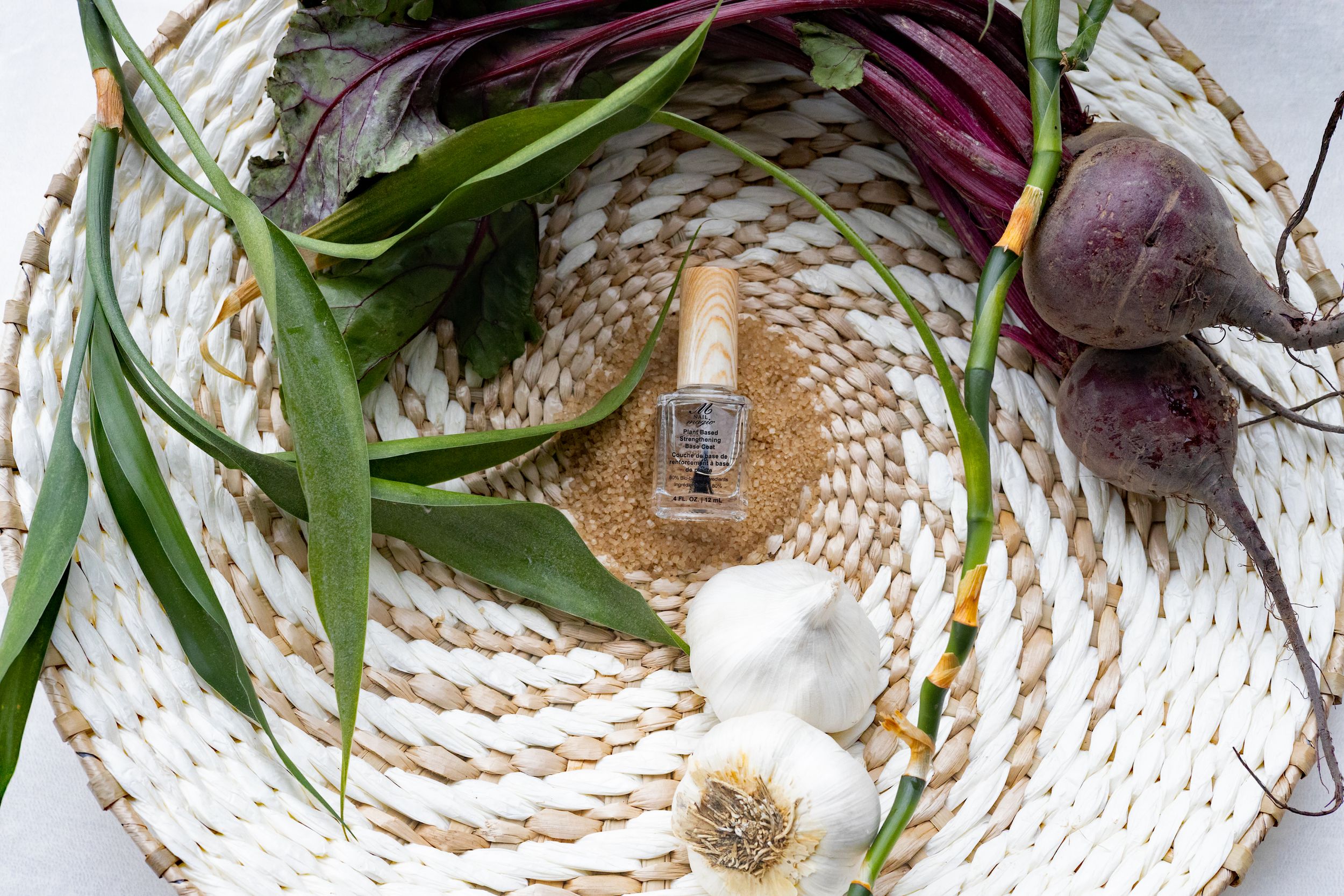 Woven basket display featuring natural elements and nail polish bottle with botanical styling.