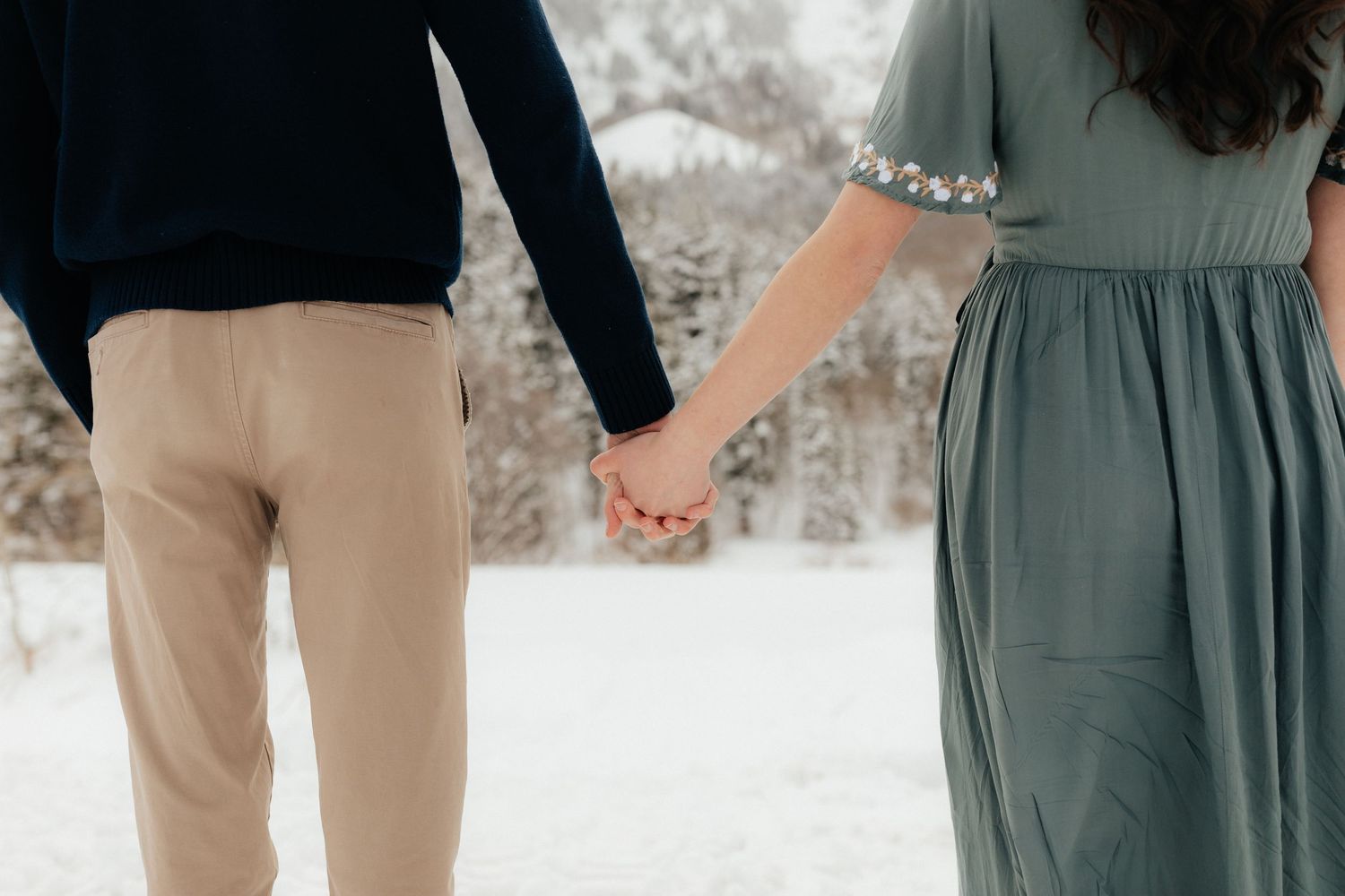Couple holding hands in Utah Winter Mountains