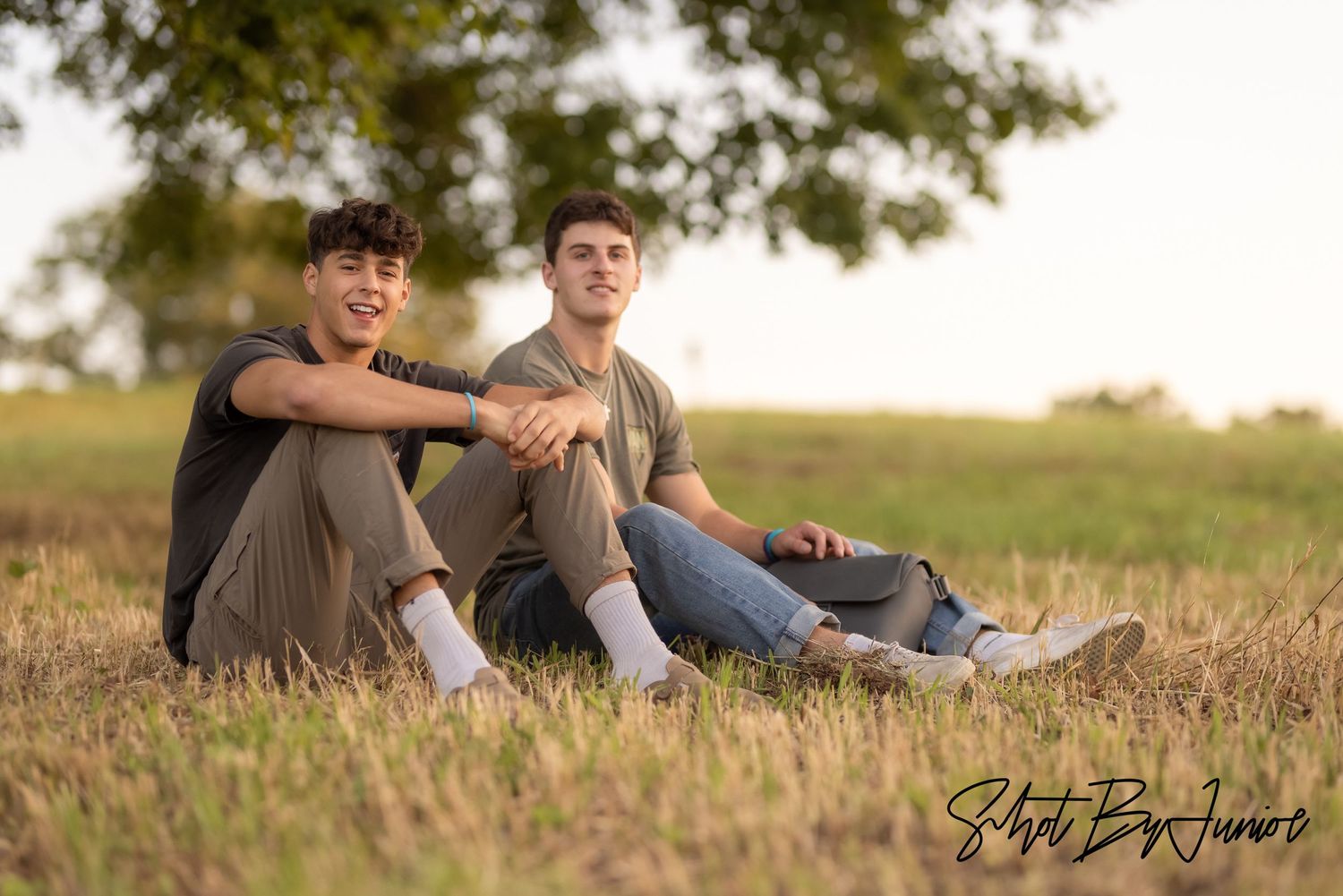 Two friends relaxing together in a field at sunset.