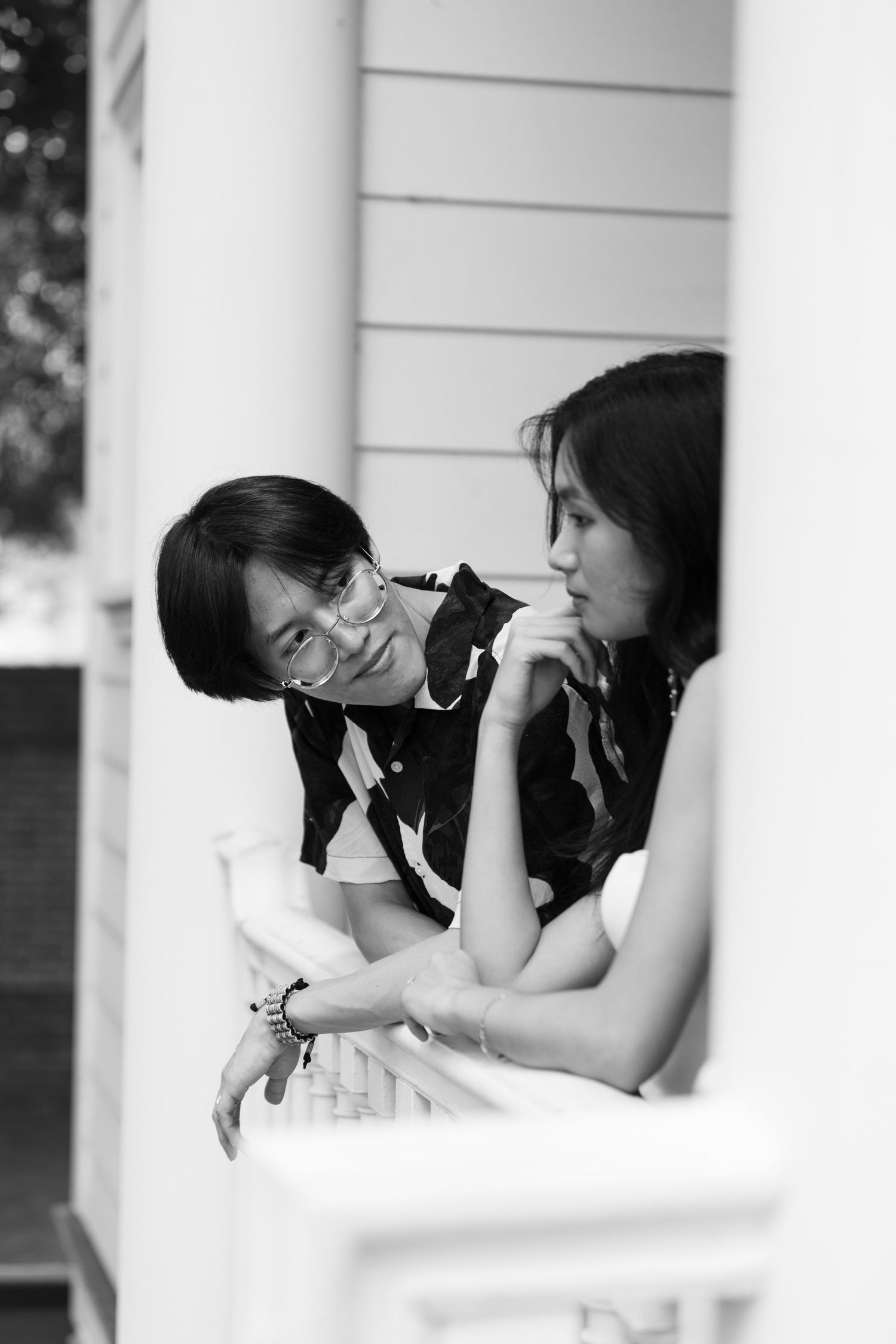 Black and white candid moment showing two friends in intimate conversation.