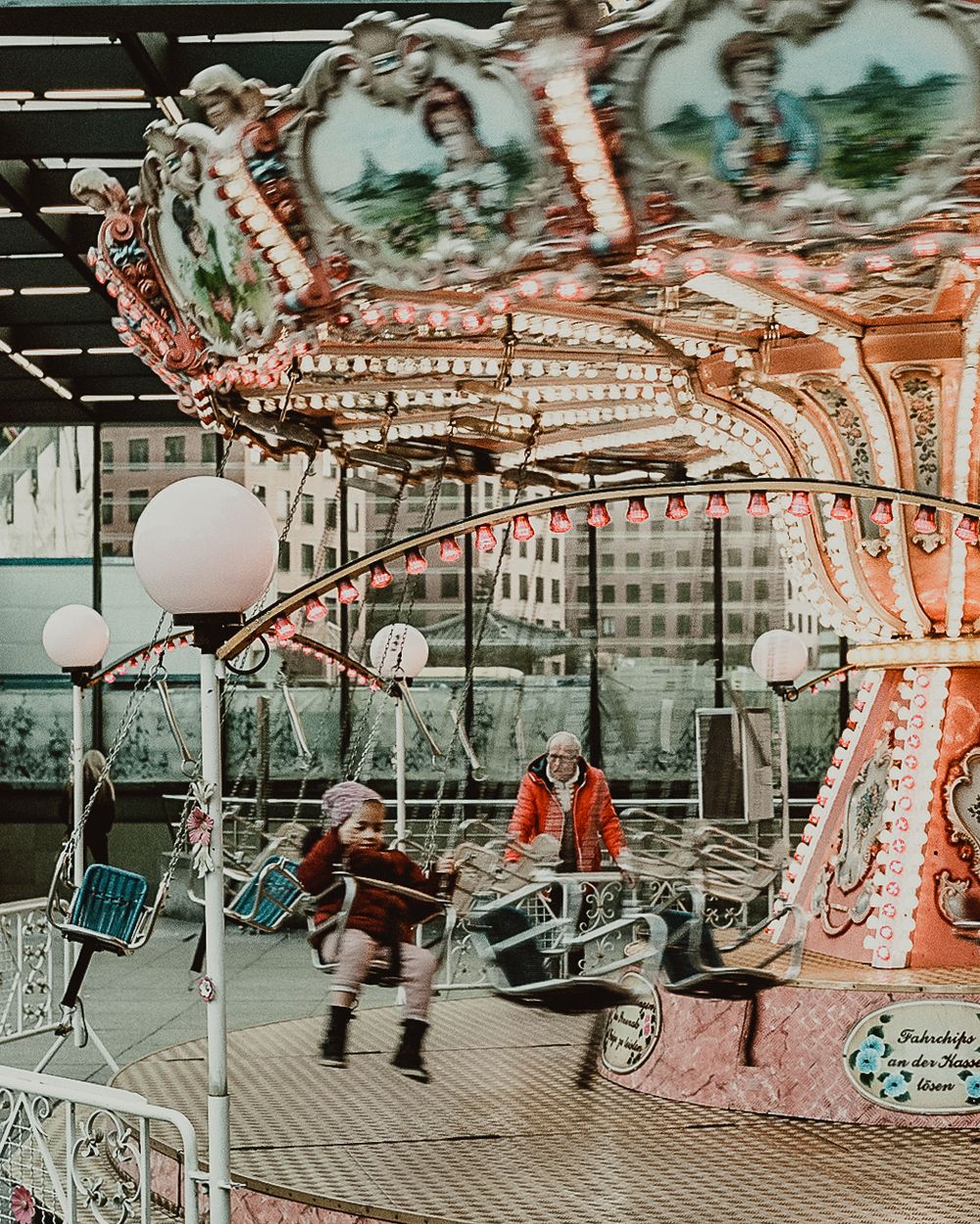 35mm film photo of child riding swing carousel in germany